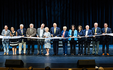 Picture of a row of People Cutting the Ribbon during the Ribbon Cutting Ceremony in front of the ORU's new Peggy V. Helmerich Media Arts Center.