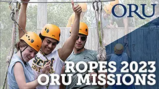 Video Thumbnail of 3 students with helmets on going through a ropes course. All of the students are smiling and one is holding his left hand up and giving a thumbs up sign.