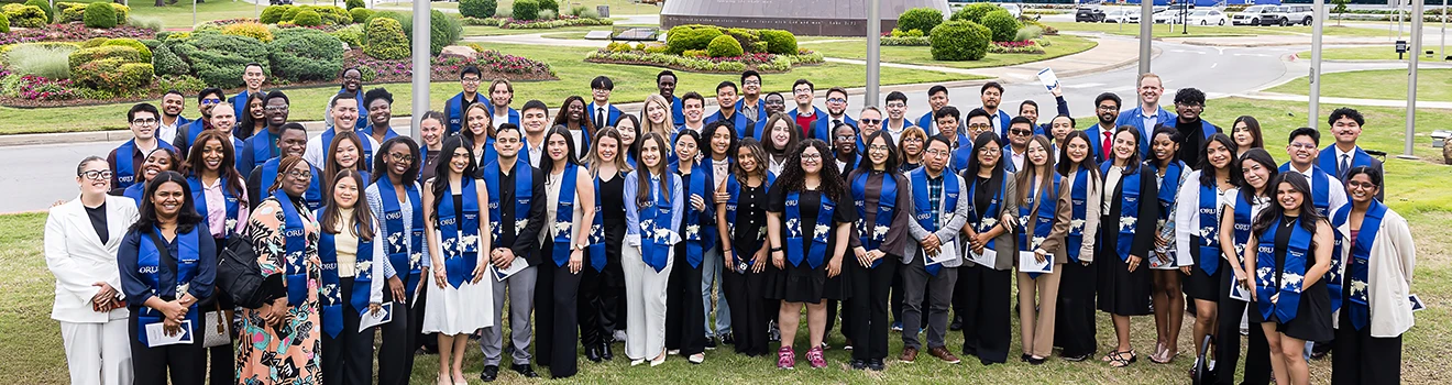 International Students Standing Outside With Their Graduation Regalia On