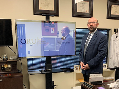 Michael Mathews, ORU Vice President of Innovation and Technology, standing beside the MQ Mirror