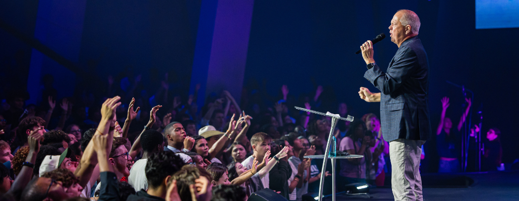 Christian ministry leader preaching to a congregation during a worship service.