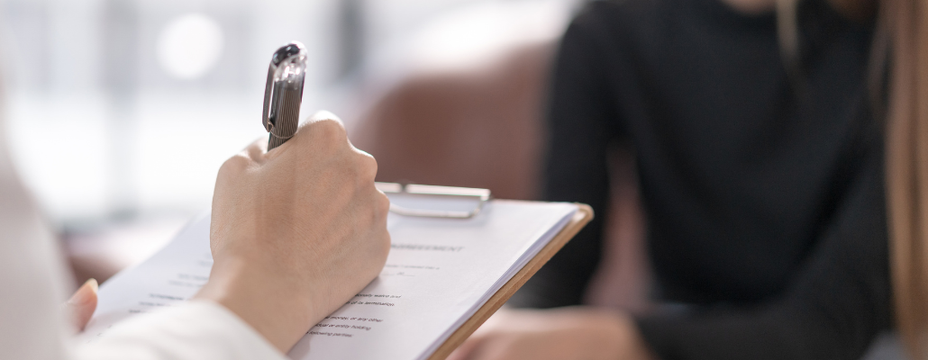 Professional taking notes during a counseling session for ORU's Psychology degree.