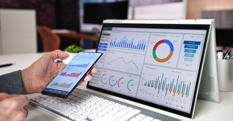 Master of Data Analytics student analyzing data dashboards, charts, and business intelligence reports on multiple devices.