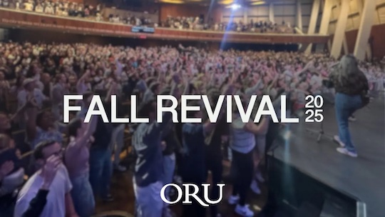 Video Thumbnail showing the ORU praise and worship team on stage in front of students standing and signing along